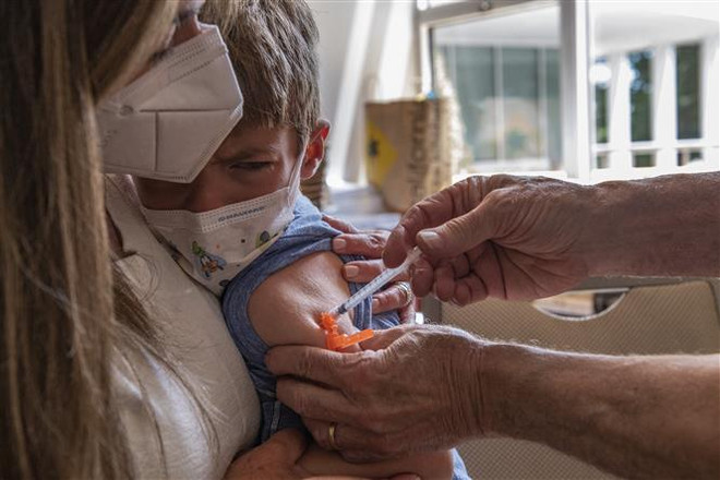 Tiêm vaccine phòng COVID-19 cho trẻ nhỏ. (Ảnh: AFP/TTXVN) Australia phê duyệt tiêm vaccine của Moderna cho trẻ dưới 5 tuổi ảnh 1