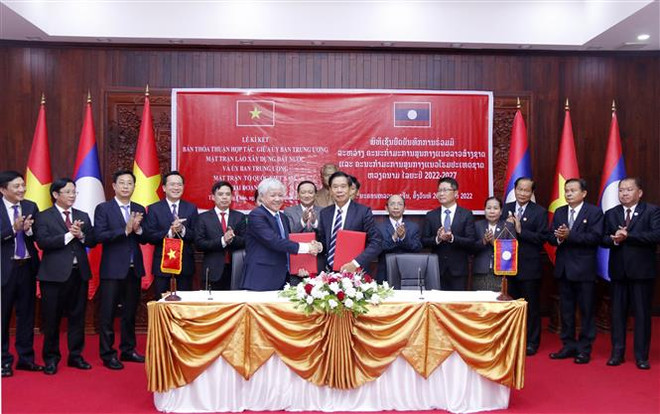 Chủ tịch Ủy ban Trung ương Mặt trận Tổ quốc Việt Nam Đỗ Văn Chiến và Chủ tịch Ủy ban Trung ương Mặt trận Lào xây dựng đất nước Sinlavong Khoutphaythone trao Biên bản hợp tác giữa hai Cơ quan giai đoạn 2022-2026. (Ảnh: Phạm Văn Kiên/TTXVN) Mặt trận Tổ quốc Việt Nam và Lào tăng cường quan hệ hợp tác ảnh 1