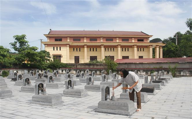 Ông Vinh (tóc dài) thắp hương cho các liệt sỹ tại Nghĩa trang Liệt sỹ xã Ninh Hải. (Ảnh: Hải Yến/TTXVN) Sáng ngời những tấm gương 'tàn nhưng không phế' của Ninh Bình ảnh 1