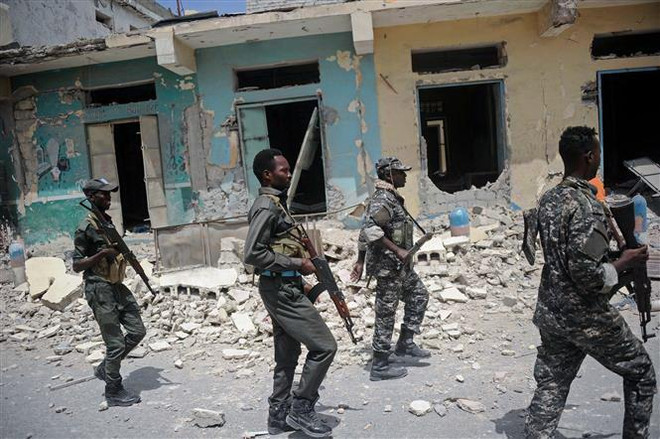 Lực lượng an ninh Somalia điều tra tại hiện trường một vụ đánh bom do phiến quân al-Shabaab tiến hành tại Mogadishu, ngày 14/7. (Nguồn: AFP/TTXVN) Somalia tăng cường không kích truy quét phiến quân al-Shabaab ảnh 1