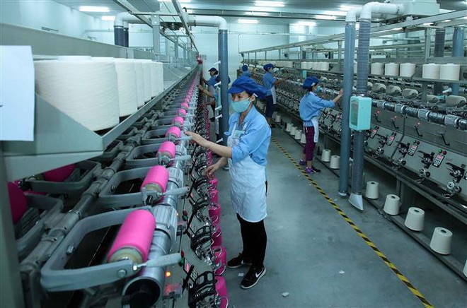 Công nhân sản xuất sản phẩm dệt nhuộm tại công ty trách nhiệm hữu hạn Dệt nhuộm Jasan Việt Nam. (Ảnh: Phạm Kiên/TTXVN) Chuyên gia ANZ lạc quan về triển vọng dài hạn của nền kinh tế Việt Nam ảnh 1