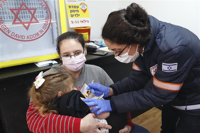 Nhân viên y tế tiêm vaccine ngừa COVID-19 cho trẻ em tại Ramat Gan gần Tel Aviv, Israel. (Ảnh: AFP/TTXVN) Chuyên gia Israel: Nên mở cửa trường học, tìm cách sống chung với dịch ảnh 2