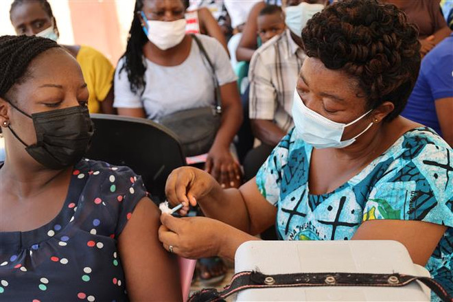 Nhân viên y tế tiêm vaccine phòng COVID-19 cho người dân tại Accra, Ghana, ngày 13/12/2021. (Ảnh: THX/TTXVN) Mũi tăng cường bằng vaccine AstraZeneca tạo phản ứng miễn dịch mạnh ảnh 1