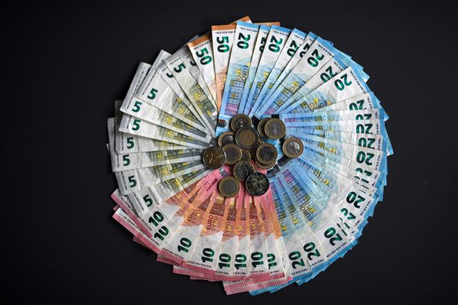 Đồng tiền giấy và tiền xu euro. (Ảnh: AFP/TTXVN) Con đường phục hồi của kinh tế châu Âu vẫn còn 'gập ghềnh' ảnh 2