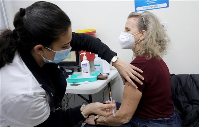 Nhân viên y tế tiêm vaccine phòng COVID-19 cho người dân tại thành phố Modiin, Israel ngày 12/1/2022. (Ảnh: THX/TTXVN) Kỷ lục buồn về dịch COVID-19 tại nhiều nước trên thế giới ảnh 1