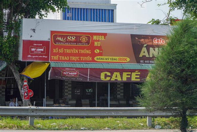 Bảng hiệu có nội dung quảng cáo trang web cá cược bóng đá treo ở quán càphê trên Quốc lộ 1A thuộc địa bàn quận Cái Răng. (Ảnh: Thanh Liêm/TTXVN) Cần Thơ: Rà soát, chấn chỉnh hoạt động quảng cáo cá cược sai quy định ảnh 1