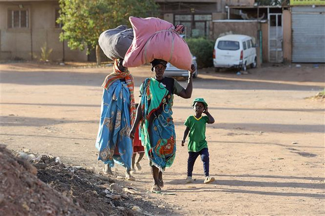 Người dân sơ tán tránh xung đột tại Khartoum, Sudan, ngày 19/4/2023. (Ảnh: AFP/TTXVN) Giao tranh tạm thời lắng xuống tại thủ đô Khartoum của Sudan ảnh 1