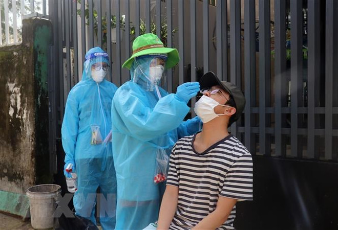 Lấy mẫu xét nghiệm sàng lọc virus SARS-CoV-2 trên địa bàn phường Vĩnh Lạc, thành phố Rạch Giá, tỉnh Kiên Giang hồi năm 2021. (Ảnh: Lê Huy Hải/TTXVN) Khởi tố vụ án mua sắm trang thiết bị phòng, chống dịch tại Kiên Giang ảnh 1