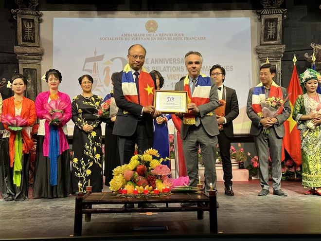 Đại sứ Việt Nam tại Pháp Đinh Toàn Thắng trao quà lưu niệm cho ông Benoit Guidée, đại diện Bộ Châu Âu và Ngoại giao Pháp. (Ảnh: Nguyễn Thu Hà/TTXVN) 50 quan hệ Việt-Pháp: Đà phát triển cho quan hệ đối tác trên mọi mặt ảnh 1