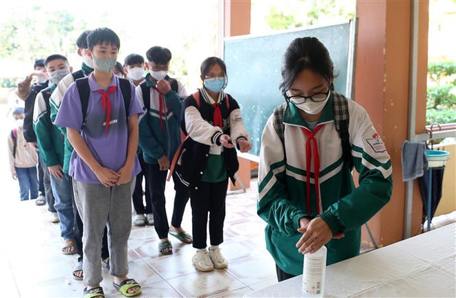 Học sinh trường Trung học cơ sở thị trấn Khánh Yên rửa tay sát khuẩn trước khi vào lớp. (Ảnh: Quốc Khánh/TTXVN) Thêm ca mắc COVID-19, Lào Cai tăng cường giám sát tại nơi đông người ảnh 1