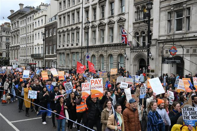 Nhân viên y tế tham gia đình công yêu cầu tăng lương tại London, Anh, ngày 11/4/2023. (Ảnh: AFP/TTXVN) Nhiều nước châu Âu và châu Mỹ đối mặt với đình công quy mô lớn ảnh 1