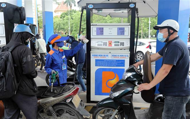 Khách hàng mua xăng tại cửa hàng kinh doanh xăng, dầu của Petrolimex. (Ảnh: Trần Việt/TTXVN) Quỹ bình ổn xăng dầu có phát huy được vai trò bình ổn giá? ảnh 2