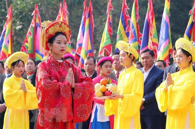 Chủ tế nữ mặc bộ lễ phục mầu đỏ thực hiện nghi thức tế lễ truyền thống. (Ảnh: Trung Kiên/TTXVN) Lễ dâng hương tưởng nhớ, tri ân công đức Tổ Mẫu Âu Cơ ảnh 1
