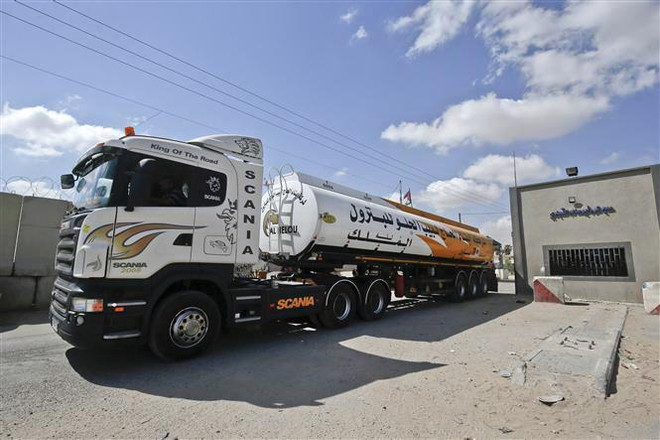 Phương tiện vận chuyển nhiên liệu từ Israel di chuyển qua cửa khẩu Kerem Shalom sang Dải Gaza. (Nguồn: AFP/TTXVN) Israel cho phép vận chuyển nhiên liệu qua cửa khẩu vào Dải Gaza ảnh 1
