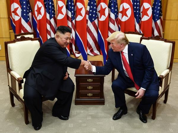 Tổng thống Mỹ Donald Trump (trái) và nhà lãnh đạo Triều Tiên Kim Jong-un trong cuộc gặp ở làng đình chiến Panmunjom tại Khu phi quân sự (DMZ) chiều 30/6/2019. (Ảnh: AFP/TTXVN) Tìm lại lòng tin từ đường ranh giới ở làng đình chiến Panmunjom ảnh 3