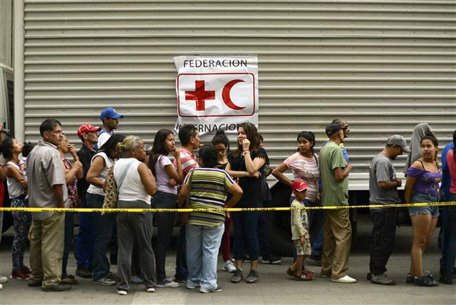 Người dân chờ nhận hàng viện trợ tại Caracas, Venezuela, ngày 16/4/2019. (Nguồn: AFP/TTXVN) Venezuela tiếp nhận thêm hàng cứu trợ của Ủy ban Chữ thập Đỏ quốc tế ảnh 1