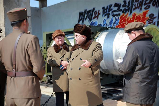 Nhà lãnh đạo Triều Tiên Kim Jong-un thị sát một vụ thử động cơ tên lửa sử dụng nhiên liệu rắn công suất lớn trên mặt đất tại một địa điểm không xác định tháng 3/2016. (Nguồn: AFP/TTXVN) Công cụ để phương Tây hoạch định chính sách về Triều Tiên ảnh 1