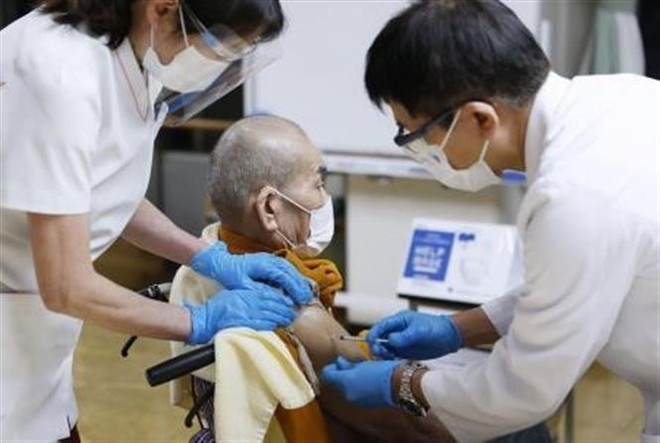 Nhân viên y tế tiêm vaccine ngừa COVID-19 cho người dân tại Tokyo, Nhật Bản, ngày 20/12/2021. (Ảnh: Kyodo/TTXVN) Nhật Bản đẩy mạnh tiêm tăng cường ngừa COVID-19 cho tất cả người dân ảnh 1