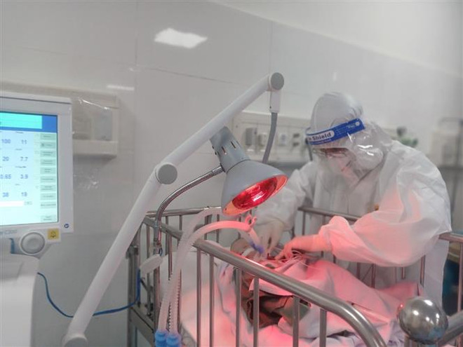 Bác sỹ Bệnh viện Vũng Tàu chăm sóc đặc biệt bé sơ sinh con của sản phụ nhiễm SARS-CoV-2 trong tình trạng nguy kịch ngụ tại phường 12, thành phố Vũng Tàu. (Ảnh: Hoàng Nhị/TTXVN) Cứu sống bé sơ sinh ngưng tim, ngưng thở của sản phụ nhiễm SARS-CoV-2 ảnh 1