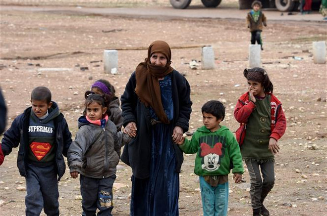 Người dân Syria tới cửa khẩu Abu al-Duhur nằm giữa khu vực do quân Chính phủ kiểm soát với nơi các tay súng tổ chức Nhà nước Hồi giáo (IS) tự xưng chiếm giữ ở tỉnh Idlib, miền Tây Bắc Syria ngày 26/11/2018. (Nguồn: THX/TTXVN) LHQ kêu gọi quốc tế chung tay giải quyết khủng hoảng nhân đạo Syria ảnh 1