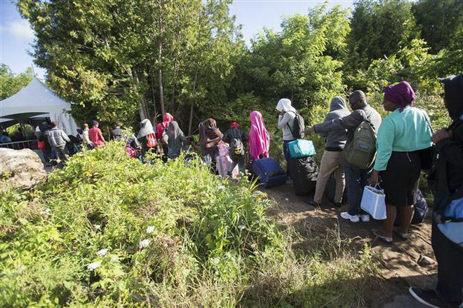 Người tị nạn băng qua biên giới Canada-Mỹ tại Champlain, New York (Mỹ). (Nguồn: AFP/TTXVN) Ông Trump đánh giá khả năng đảng Dân chủ ủng hộ kế hoạch nhập cư mới ảnh 1
