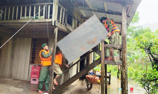 Cán bộ chiến sỹ Đồn Biên phòng Làng Mô, Bộ đội Biên phòng Quảng Bình giúp người dân di dời đồ đạc, tài sản lên chỗ an toàn phòng tránh mưa lũ. (Ảnh: TTXVN phát) Thủ tướng nhấn mạnh 6 bài học kinh nghiệm về công tác ứng phó bão ảnh 1