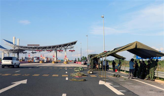 Ban chỉ huy Quân sự thị xã Quảng Yên đang dựng trạm kiểm soát lưu động tại chân cầu Bạch Đằng, trên cao tốc Quảng Ninh với Hải Phòng. (Ảnh: Văn Đức/TTXVN) Quảng Ninh: Khắc phục những bất cập trong công tác phòng, chống dịch ảnh 2