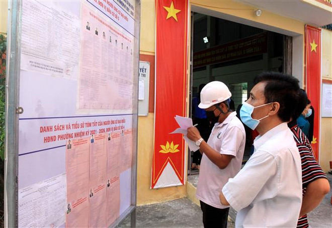 Cử tri tìm hiểu thông tin về các ứng cử viên tại khu vực bỏ phiếu số 4 phường Trần Hưng Đạo, thành phố Thái Bình. (Ảnh: Thế Duyệt/TTXVN) Thái Bình sẽ bầu thêm 5 đại biểu Hội đồng Nhân dân cấp xã ảnh 1