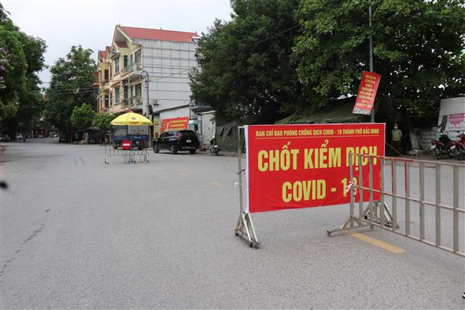 Chốt kiểm soát dịch bệnh tại cầu Như Nguyệt ngăn giữa phường Đáp Cầu, thành phố Bắc Ninh và huyện Việt Yên, tỉnh Bắc Giang. (Ảnh: Thái Hùng/TTXVN) Quân đội triển khai hai bệnh viện dã chiến ở Bắc Ninh và Bắc Giang ảnh 2
