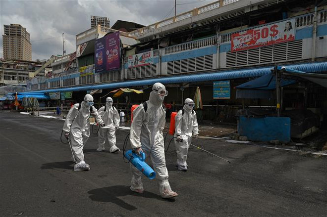 Phun thuốc khử trùng nhằm ngăn chặn sự lây lan của COVID-19 tại Phnom Penh, Campuchia. (Nguồn: AFP/TTXVN) Thủ đô Campuchia bất ngờ dỡ bỏ lệnh giới nghiêm ban đêm ảnh 1