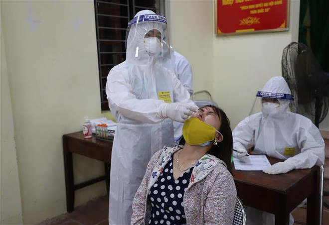 Lực lượng y, bác sỹ lấy mẫu xét nghiệm SARS-CoV-2 cho người dân tại xã Mão Điền, huyện Thuận Thành, tỉnh Bắc Ninh. (Ảnh: Thanh Thương/TTXVN) Chủ tịch UBND tỉnh Bắc Ninh kêu gọi ủng hộ chống dịch COVID-19 ảnh 1