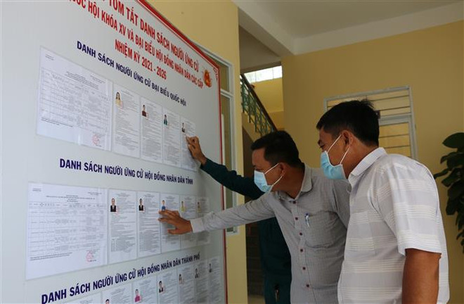 Các cử tri xã biên giới Bình Thạnh, thành phố Hồng Ngự tìm hiểu thông tin về ứng cử viên. (Ảnh: Chương Đài/TTXVN) Bầu cử Quốc hội: Cử tri Đồng Tháp với niềm tin và kỳ vọng ảnh 2