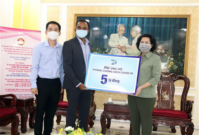 Bà Tô Thị Bích Châu, Chủ tịch Ủy ban Mặt trận Tổ quốc Việt Nam thành phố Hồ Chí Minh (ngoài cùng bên phải) tiếp nhận ủng hộ từ các doanh nghiệp. (Nguồn: TTXVN) Người dân TP.HCM ủng hộ hơn 108 tỷ đồng chống COVID-19 và xâm nhập mặn ảnh 1