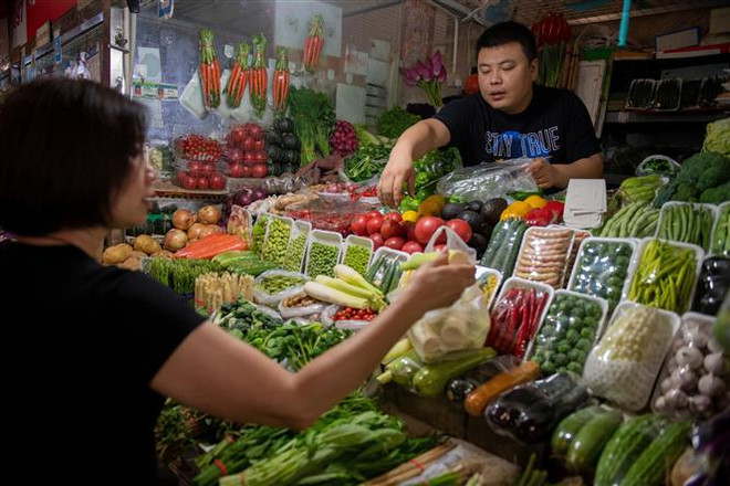 Một quầy bán rau quả tại chợ ở Bắc Kinh, Trung Quốc. (Nguồn: AFP/TTXVN) Dịch COVID-19 không ảnh hưởng nhiều đến thị trường nông sản Trung Quốc ảnh 1