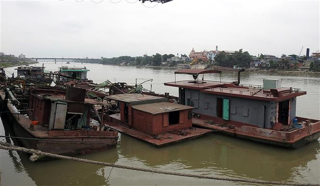 Các tàu vi phạm quy định khai thác khoáng sản bị cơ quan chức năng tỉnh Nam Định tạm giữ. (Ảnh: Văn Đạt/TTXVN) Bắt quả tang 3 tàu đang hút cát trái phép trên sông Hồng ảnh 1