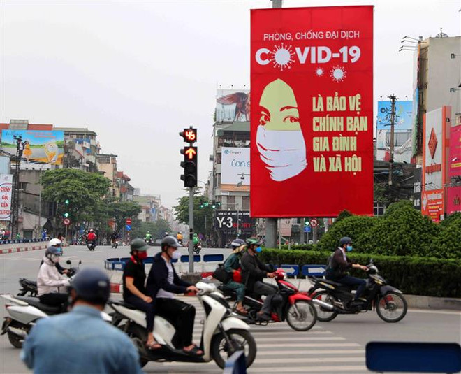 Tranh cổ động tuyên truyền về COVID-19 được đặt ở các điểm nút giao thông của Hà Nội. (Ảnh: Thanh Tùng/TTXVN) 'Việt Nam phản ứng mau lẹ và giúp đỡ nước khác đối đầu với COVID-19' ảnh 1