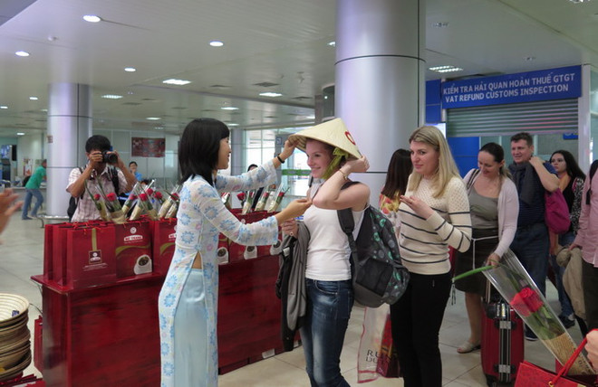 Các du khách Nga nhận món quà chiếc nón lá Việt Nam. (Ảnh: Tiên Minh/TTXVN) Việt Nam là một trong những điểm đến ưa thích nhất của người Nga ảnh 1