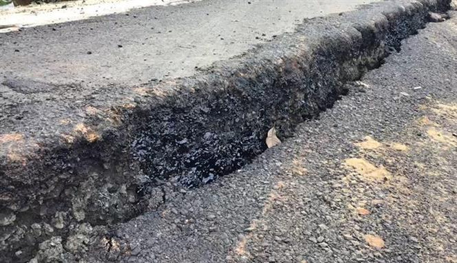 Khu vực Dốc đèo 5 cây, mặt đường bị sụt lún sâu gần 40cm, gây nguy hiểm cho các phương tiện tham gia giao thông. (Ảnh: Đậu Tất Thành/TTXVN) Đường huyết mạch Bình Phước-Lâm Đồng 'tách đôi' do sụt lún ảnh 1