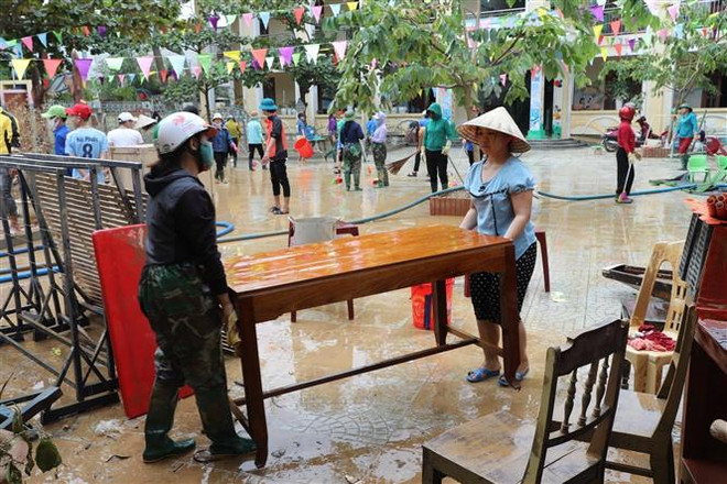 Giáo viên dọn dẹp vệ sinh trường Mầm non thị trấn Kiến Giang, huyện Lệ Thủy (Quảng Bình). (Ảnh: Danh Lam/TTXVN) Quảng Bình khắc phục hậu quả sau lũ, chuẩn bị ứng phó với bão số 8 ảnh 2
