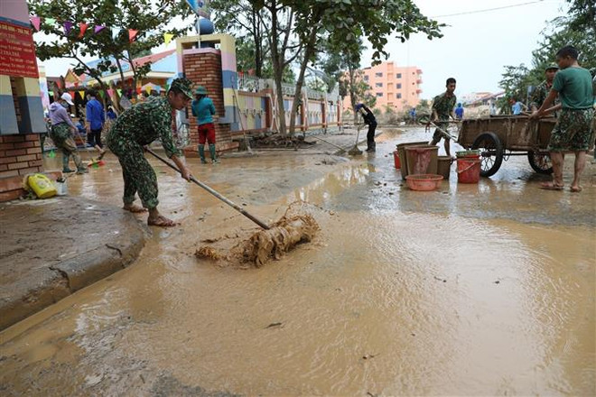 Chiến sỹ Trung đoàn 1, Sư đoàn 324, Quân khu 4 dọn dẹp bùn đất, đường xá... tại huyện Lệ Thủy. (Ảnh: Danh Lam/TTXVN) Quảng Bình khắc phục hậu quả sau lũ, chuẩn bị ứng phó với bão số 8 ảnh 1