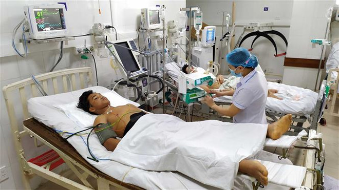 Nạn nhân Đinh Phạm Công, bị vùi lấp đa chấn thương đang được chăm sóc tại Khoa Hồi sức tích cực-Chống độc, Bệnh viện đa khoa tỉnh Quảng Nam. (Ảnh: Trần Lê Lâm/TTXVN) Tích cực cứu chữa, tìm kiếm nạn nhân trong vụ sạt lở đất ở xã Trà Leng ảnh 1
