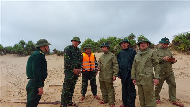 Đại tá Trịnh Thanh Bình, Chỉ huy trưởng Bộ Chỉ huy Bộ đội Biên phòng Quảng Bình (thứ 4 từ phải qua) trực tiếp có mặt tại hiện trường chỉ đạo công tác cứu hộ cứu nạn. (Ảnh: Võ Dung/TTXVN) Quảng Bình: Tàu hàng 26.000 tấn gặp nạn khi đang tránh trú bão ảnh 2
