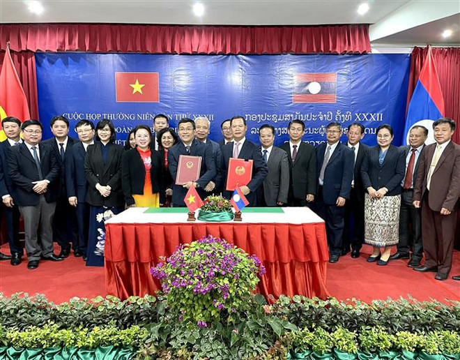Ký kết hợp tác giữa hai đoàn. (Ảnh: TTXVN phát) Việt-Lào giữ vững đường biên giới chung luôn hòa bình, ổn định ảnh 2