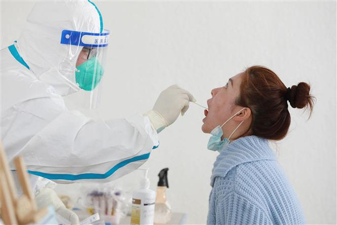 Lấy mẫu xét nghiệm COVID-19 cho người dân tại Hàng Châu, Trung Quốc ngày 11/3/2022. (Ảnh: AFP/TTXVN) Trung Quốc cấp phép lưu hành 5 bộ xét nghiệm COVID-19 kháng nguyên ảnh 1