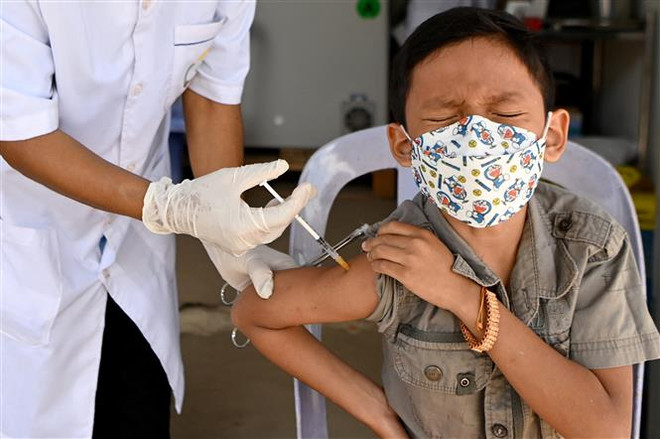 Nhân viên y tế tiêm vaccine phòng COVID-19 của hãng Sinovac cho trẻ em tại Phnom Penh, Campuchia, ngày 23/2/2022. (Ảnh: AFP/TTXVN) Campuchia sẽ nhận thêm 5 triệu liều vaccine của hãng Sinovac ảnh 1