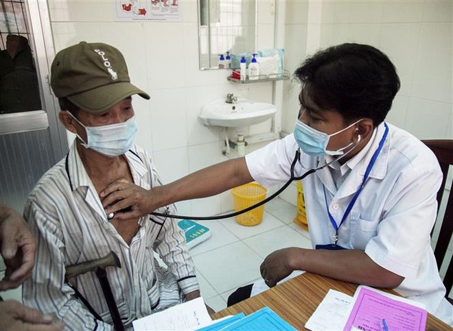 Bác sỹ Danh Ngọc Châu khám bệnh cho người dân tại Phòng khám Trung tâm Y tế huyện Châu Thành. (Ảnh: Hồng Đạt/TTXVN) Bác sỹ người Khmer hết lòng chăm sóc sức khỏe cho dân nghèo ảnh 1