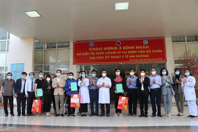 Đại diện Bộ Y tế, lãnh đạo tỉnh Hải Dương và các y bác sỹ chúc mừng các bệnh nhân đã điều trị khỏi bệnh và được ra viện. (Ảnh: Mạnh Minh/TTXVN) Ba bệnh nhân COVID-19 đầu tiên của Hải Dương được ra viện ảnh 2