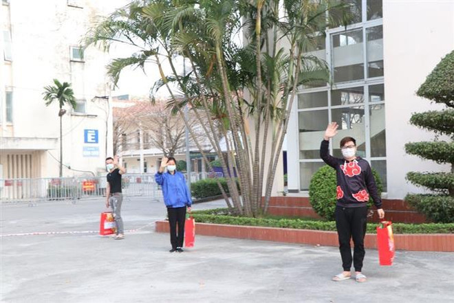 Các bệnh nhân vui mừng vì được khỏi bệnh sớm, về đón Tết cùng với gia đình. (Ảnh: Mạnh Minh/TTXVN) Ba bệnh nhân COVID-19 đầu tiên của Hải Dương được ra viện ảnh 1