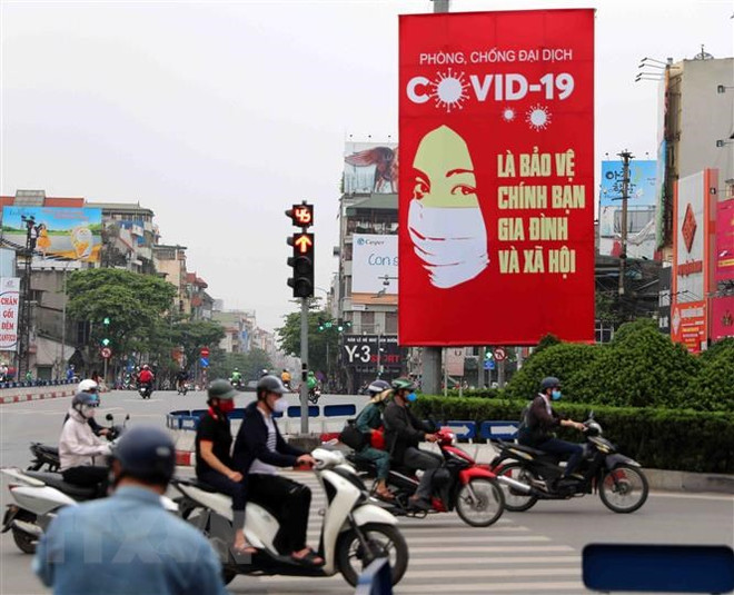 Tranh cổ động tấm lớn về phòng, chống COVID-19 được đặt ở các điểm nút giao thông của Hà Nội. (Ảnh: Thanh Tùng/TTXVN) Credendo: Việt Nam đang viết tiếp câu chuyện thành công về kinh tế ảnh 1