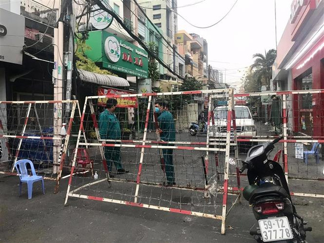 Tại khu vực lối ra vào hai hẻm 168 đường Nguyễn Cư Trinh và 245 đường Nguyễn Trãi (khu vực Mả Lạng), Quận 1, cơ quan chức năng phong tỏa nghiêm ngặt. Đây là nơi cư trú của bệnh nhân 2005. (Ảnh: Hồng Giang/TTXVN) Dịch COVID-19: Thành phố Hồ Chí Minh nâng cao mức độ cảnh báo ảnh 1